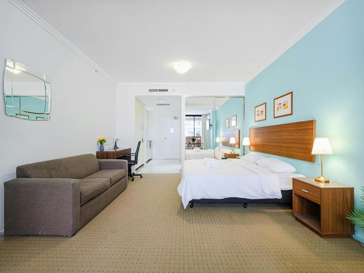 Open-plan perspective featuring sofa seating, the king-size bed near the entrance.