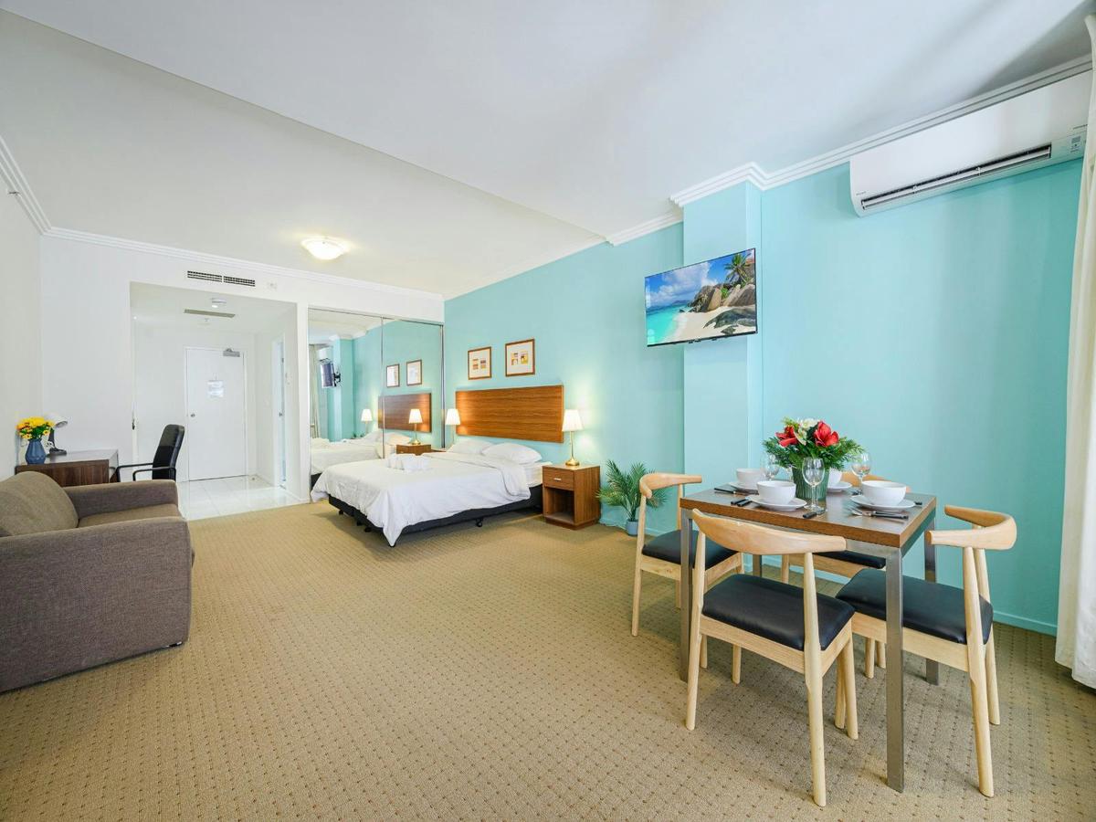 Wide view of the studio showcasing both the king-size bed along with dining area and AC