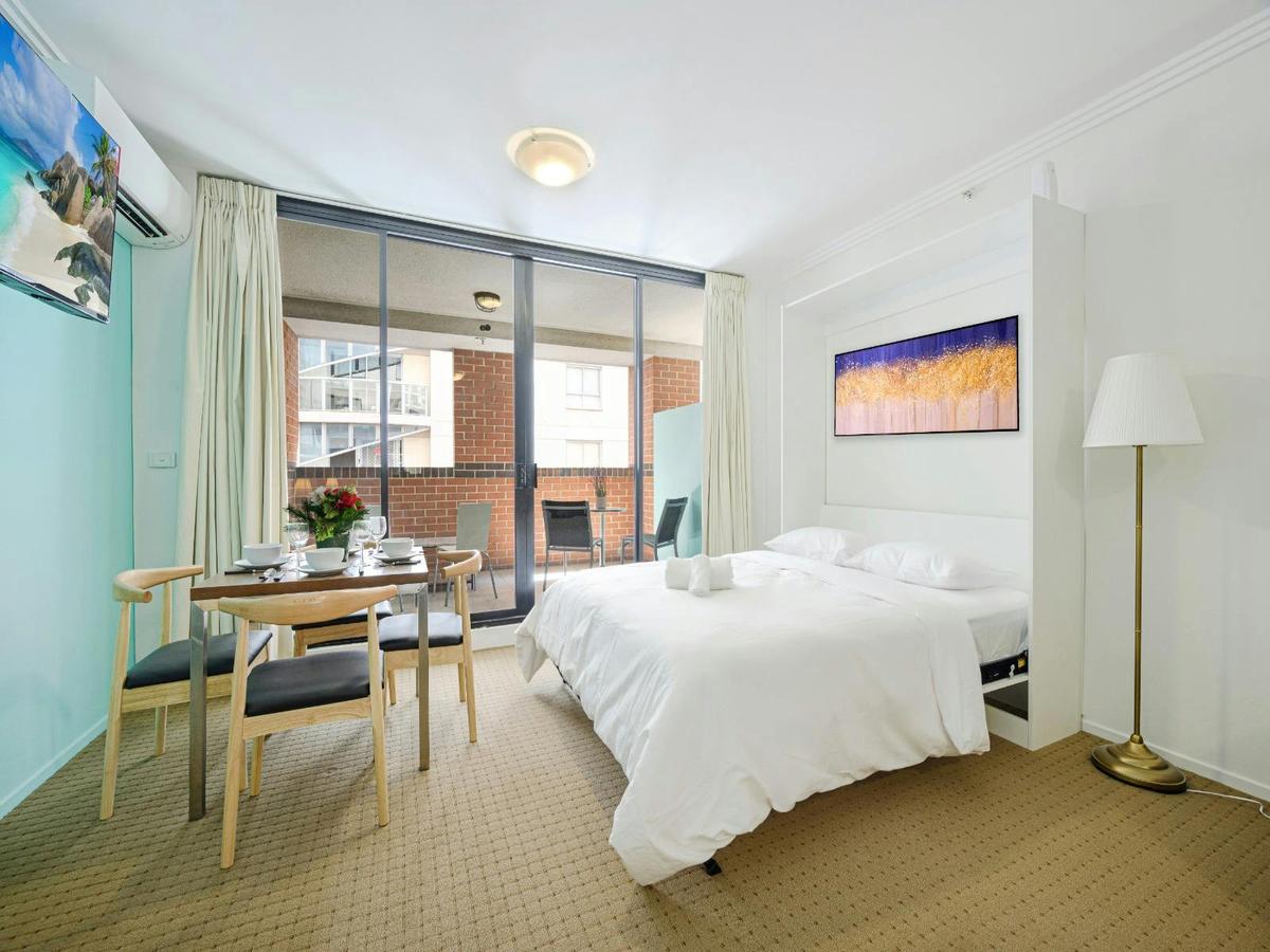 The pull-up bed near the balcony, small dining table, and access to the private balcony.