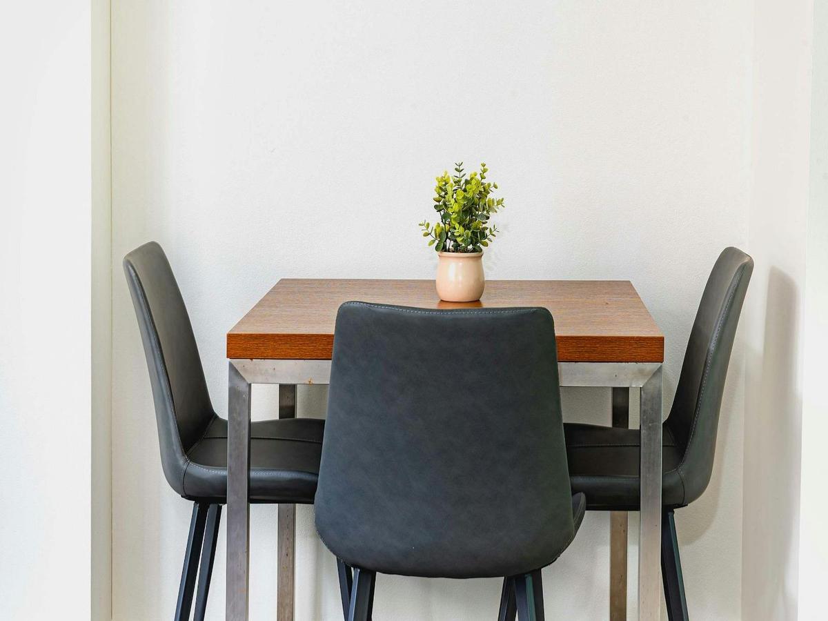 Small dining setting with table and chairs, styled with simple décor.
