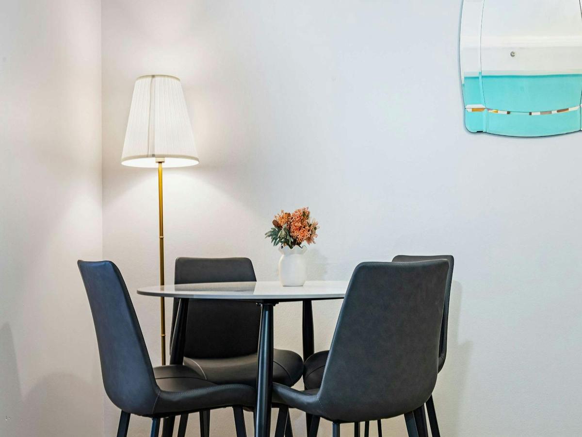 Small dining setting with table, chairs, and floor lamp.