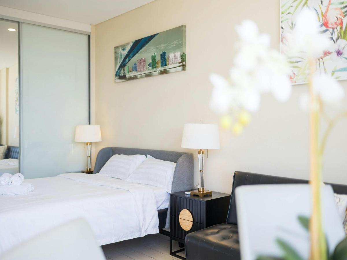 Bedroom styled with a queen-size bed, bedside lamps, and modern artwork