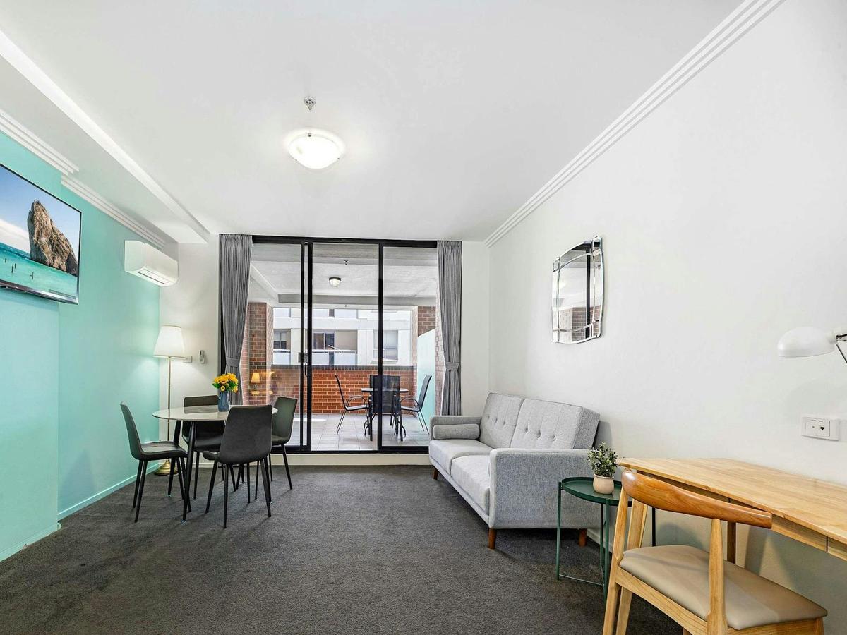 Spacious open-plan studio featuring a sofa bed, work desk, dining table, and access to a private bal