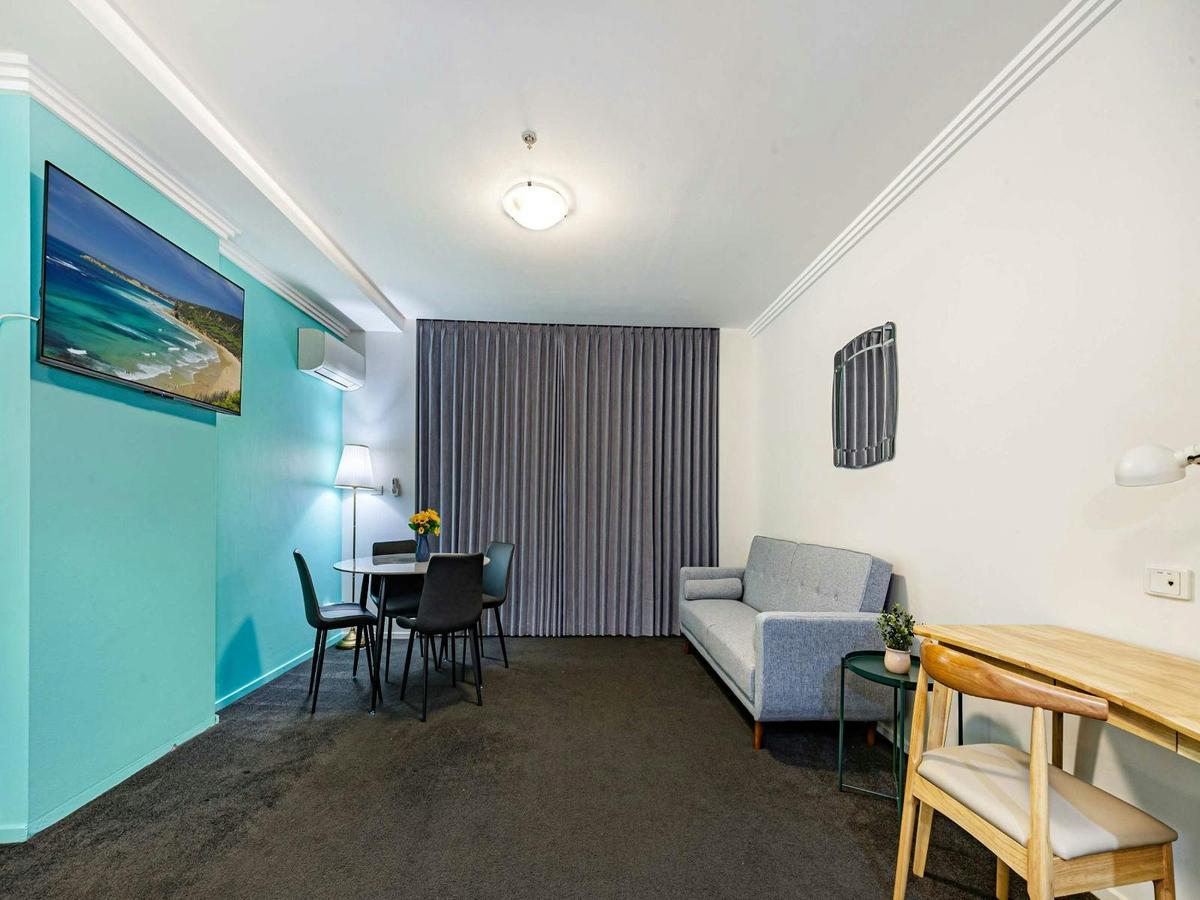 Spacious open-plan studio featuring a sofa bed, work desk & dining table