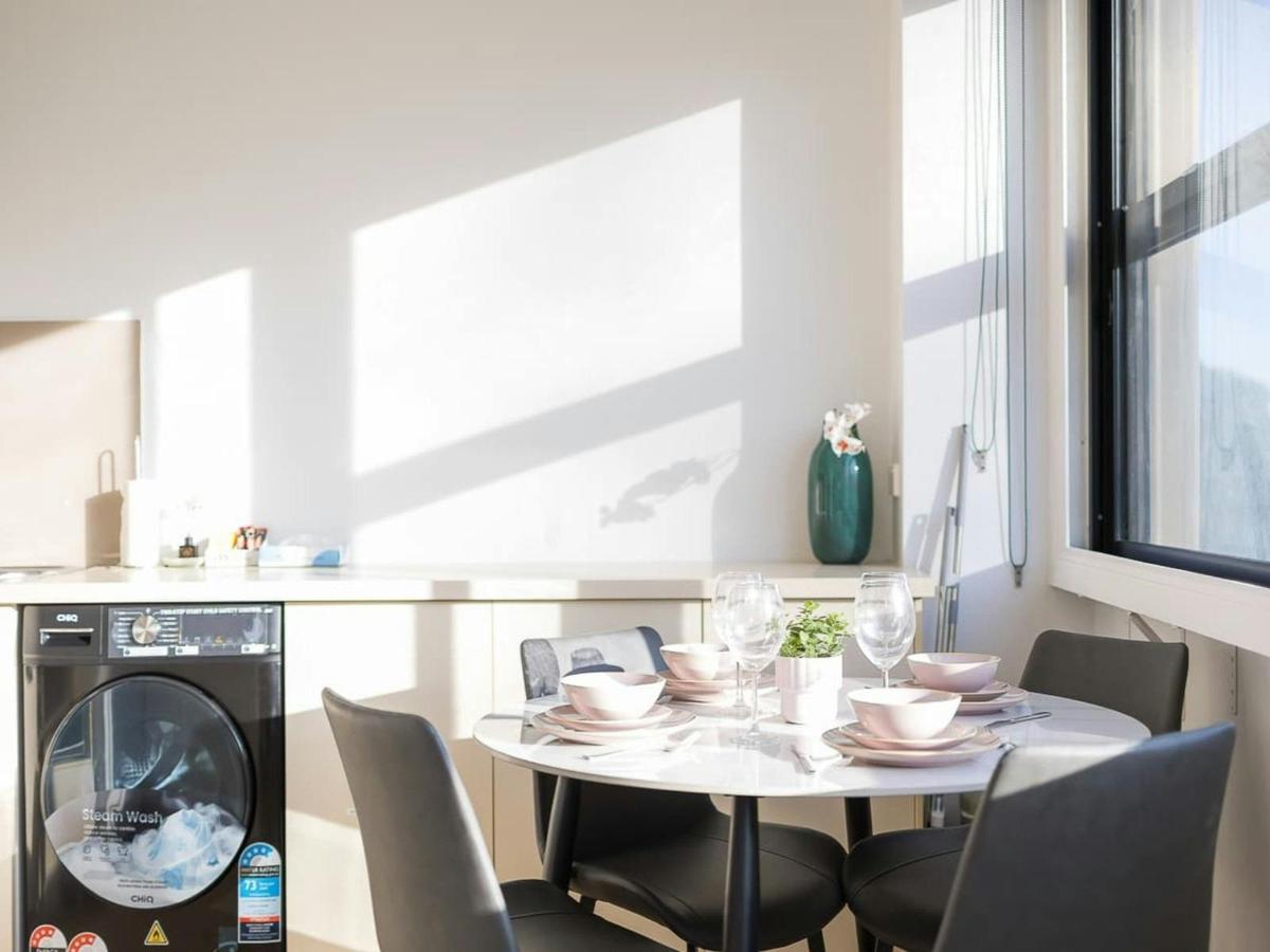 Dining area with table setting, kitchenette, and in-unit laundry