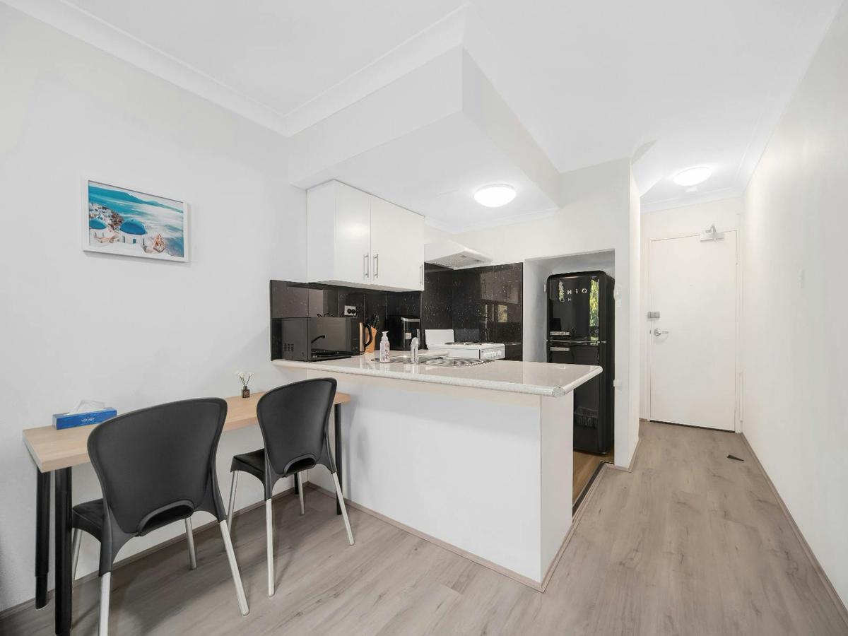 Spacious open-plan living, dining and kitchen area with modern furnishings and natural light.
