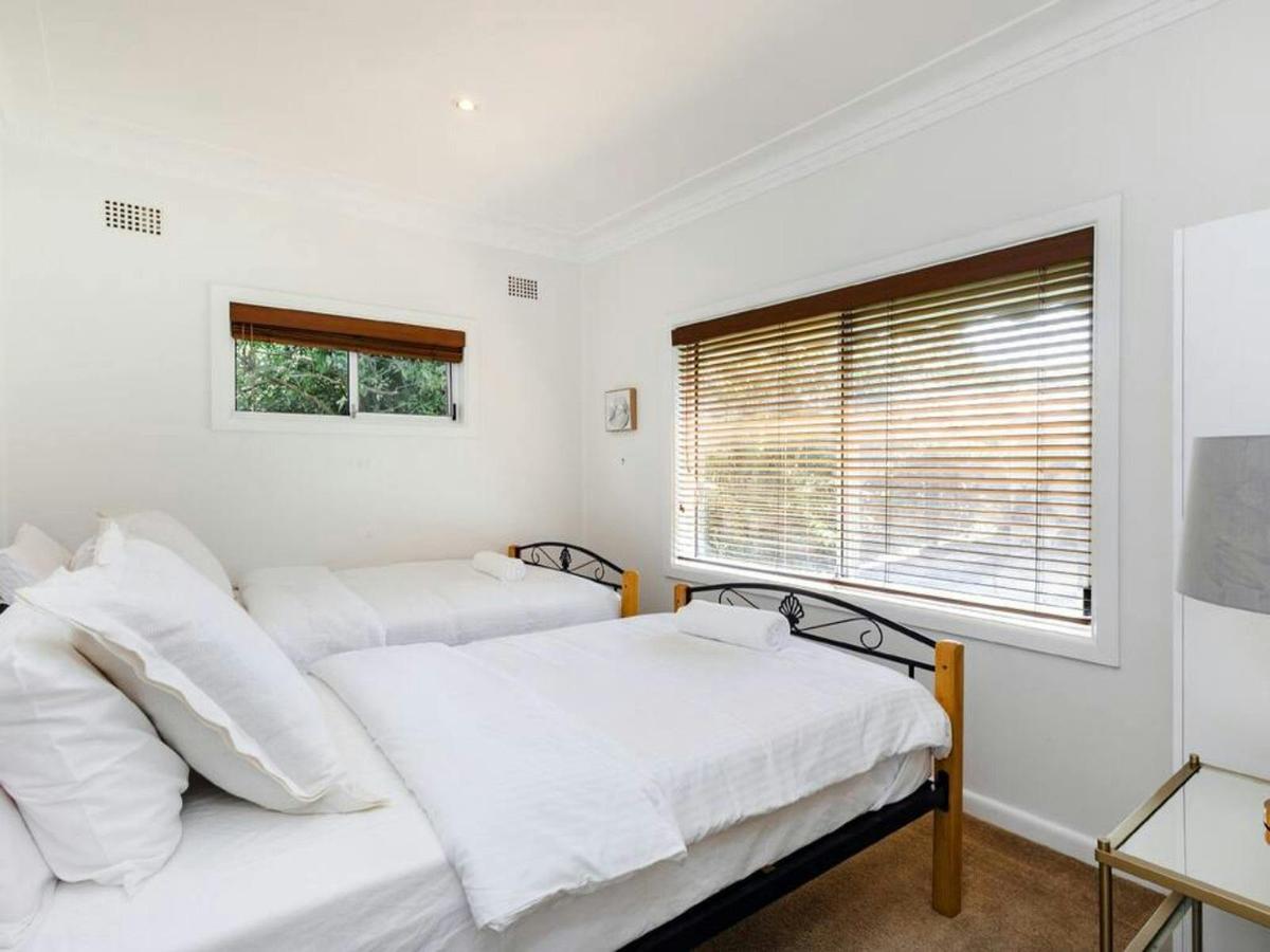 Comfortable bedroom with a queen bed, timber blinds and soft natural lighting.