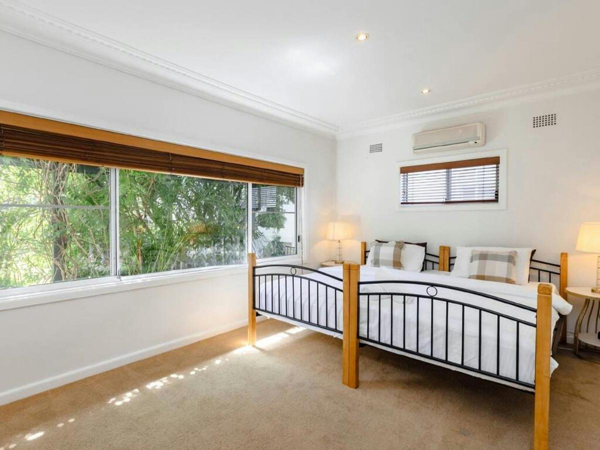 eaceful bedroom with a queen bed, large picture window overlooking gardens and natural light.