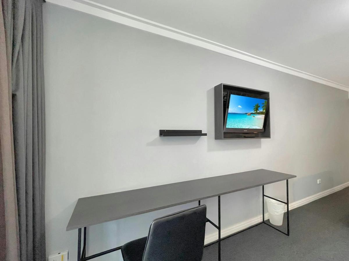 Working station with long desk and wall-mounted TV.