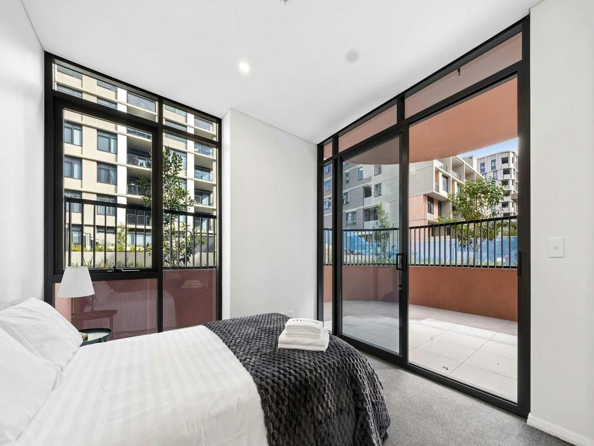 Comfortable bedroom with large windows, and private balcony access.