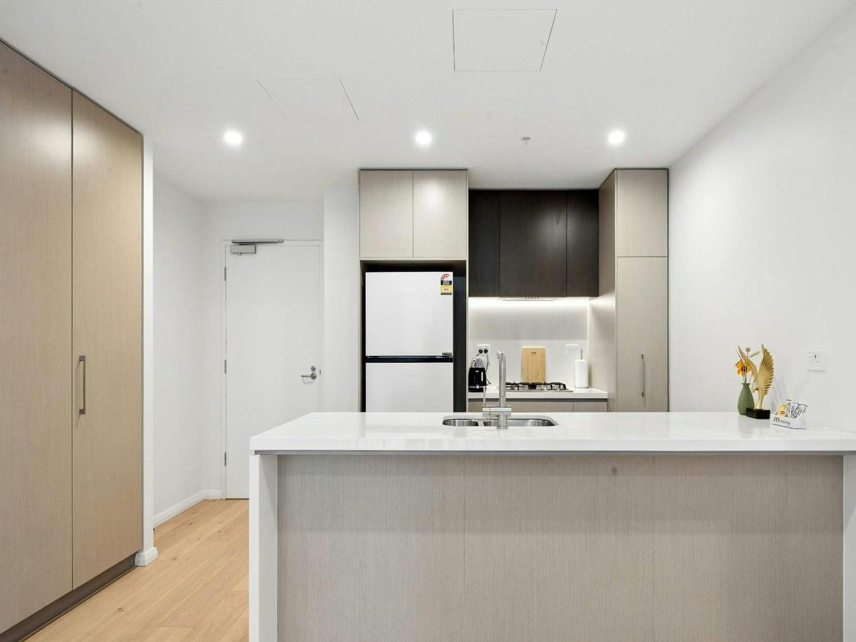 Modern kitchen featuring stone benchtops, breakfast bar, and quality appliances.