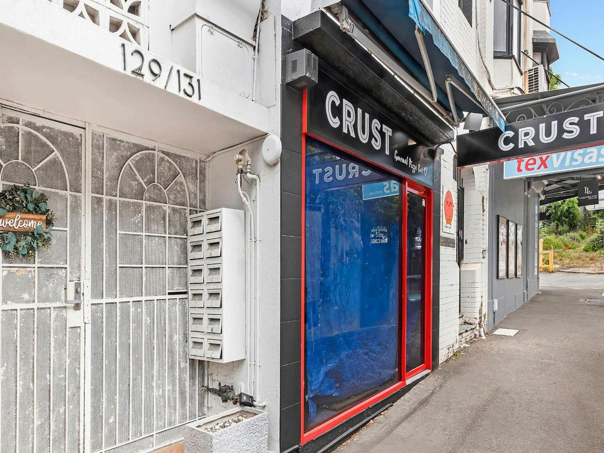 Conveniently located building entrance surrounded by shops and local amenities.