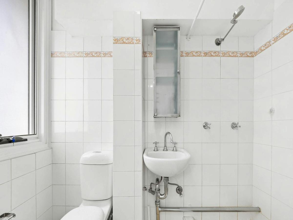 Clean and functional bathroom with shower, vanity, and essential amenities.