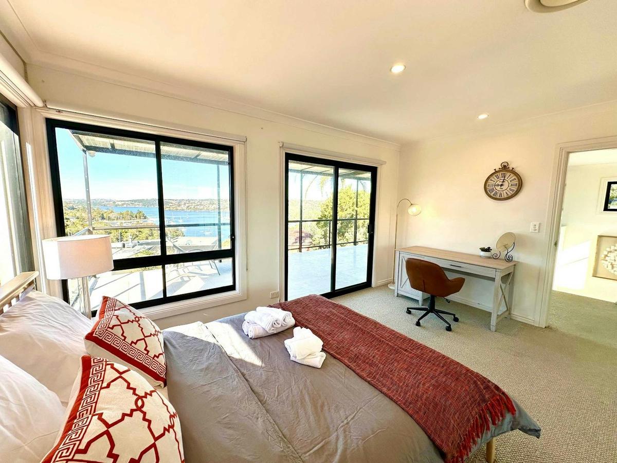 Downstairs Room 2 featuring a queen bed, bright interiors, and study desk.