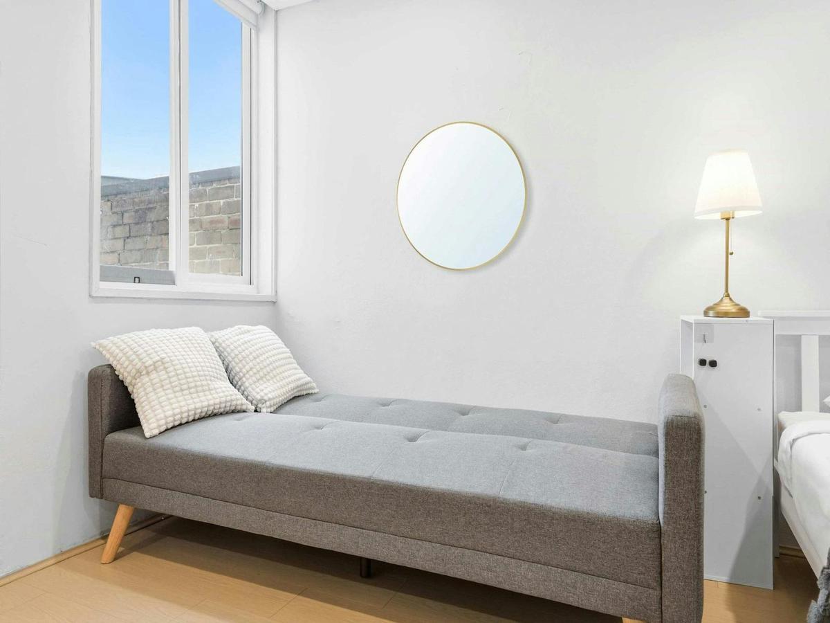Modern sofa bed positioned near the window, offering additional sleeping space.