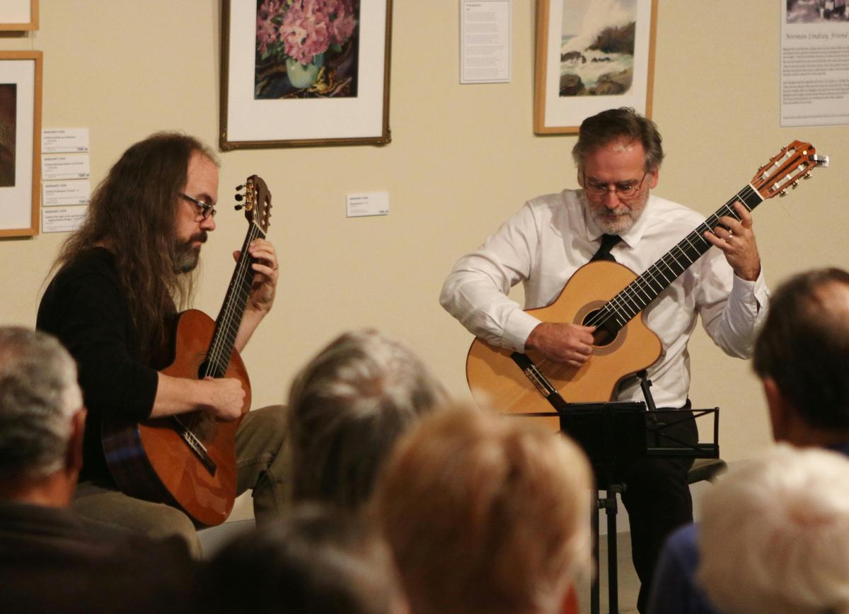 Two guitarists playing in art gallery