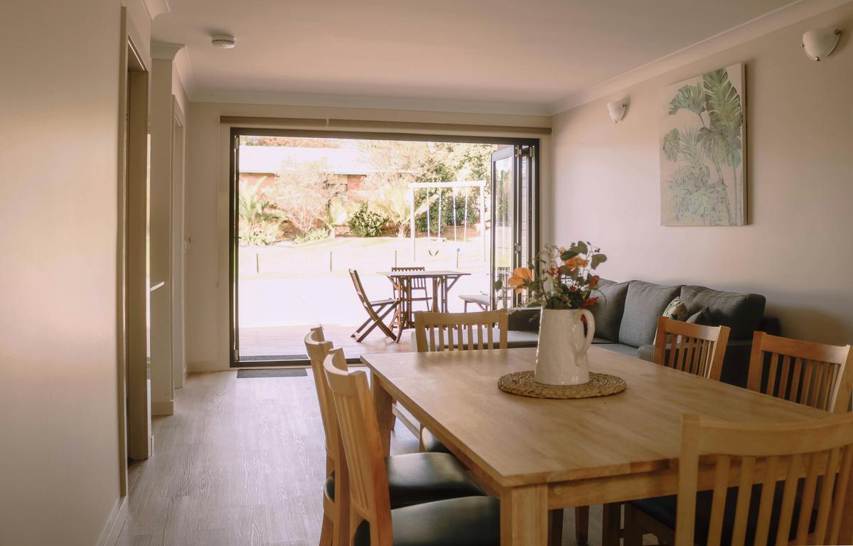 Dining room, lounge room with bifold doors that open onto deck with outdoor setting