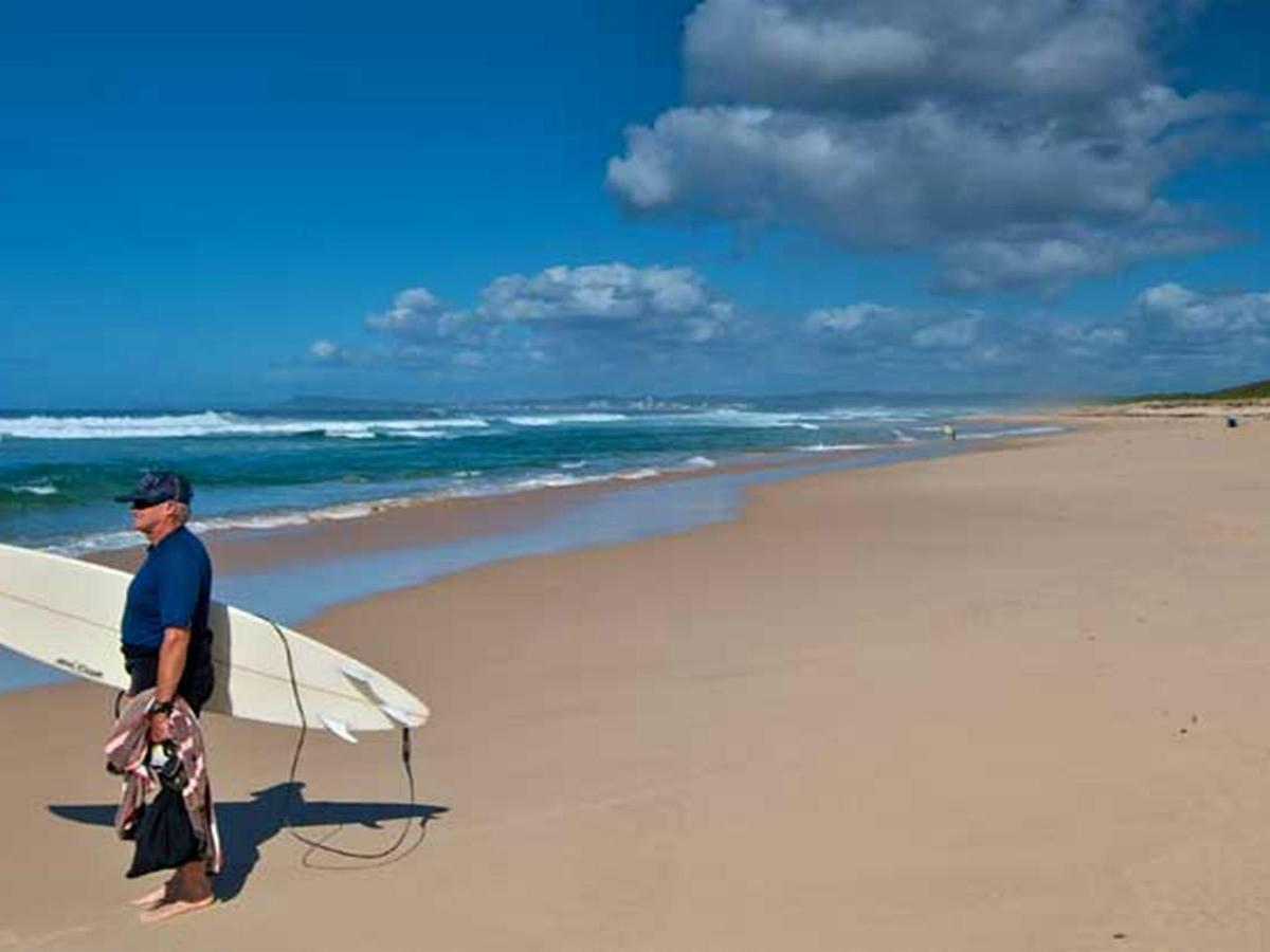 Surfer on Pelican Beach. Photo: John Spencer