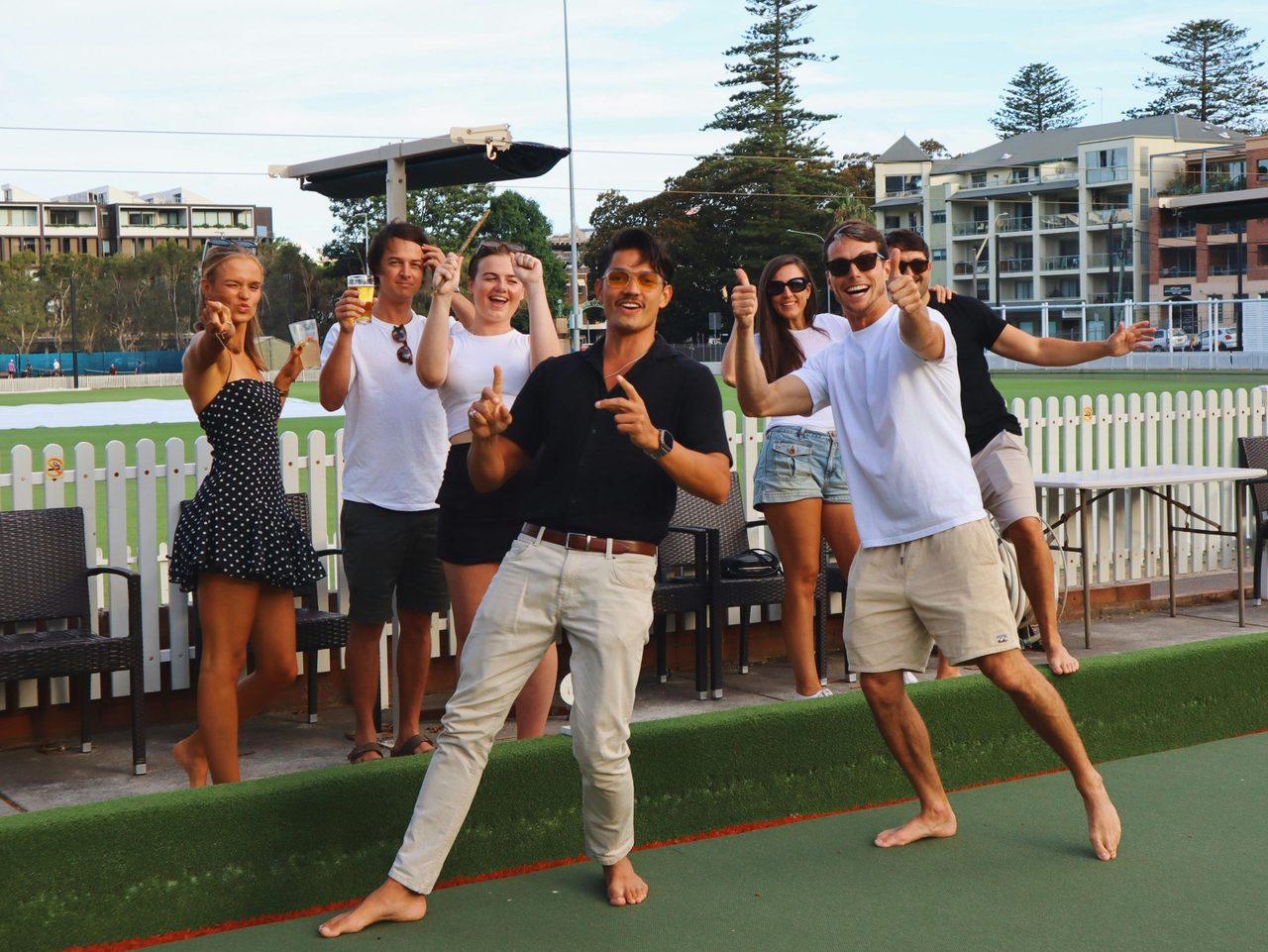 A group of friends posing by the barefoot bowling green.