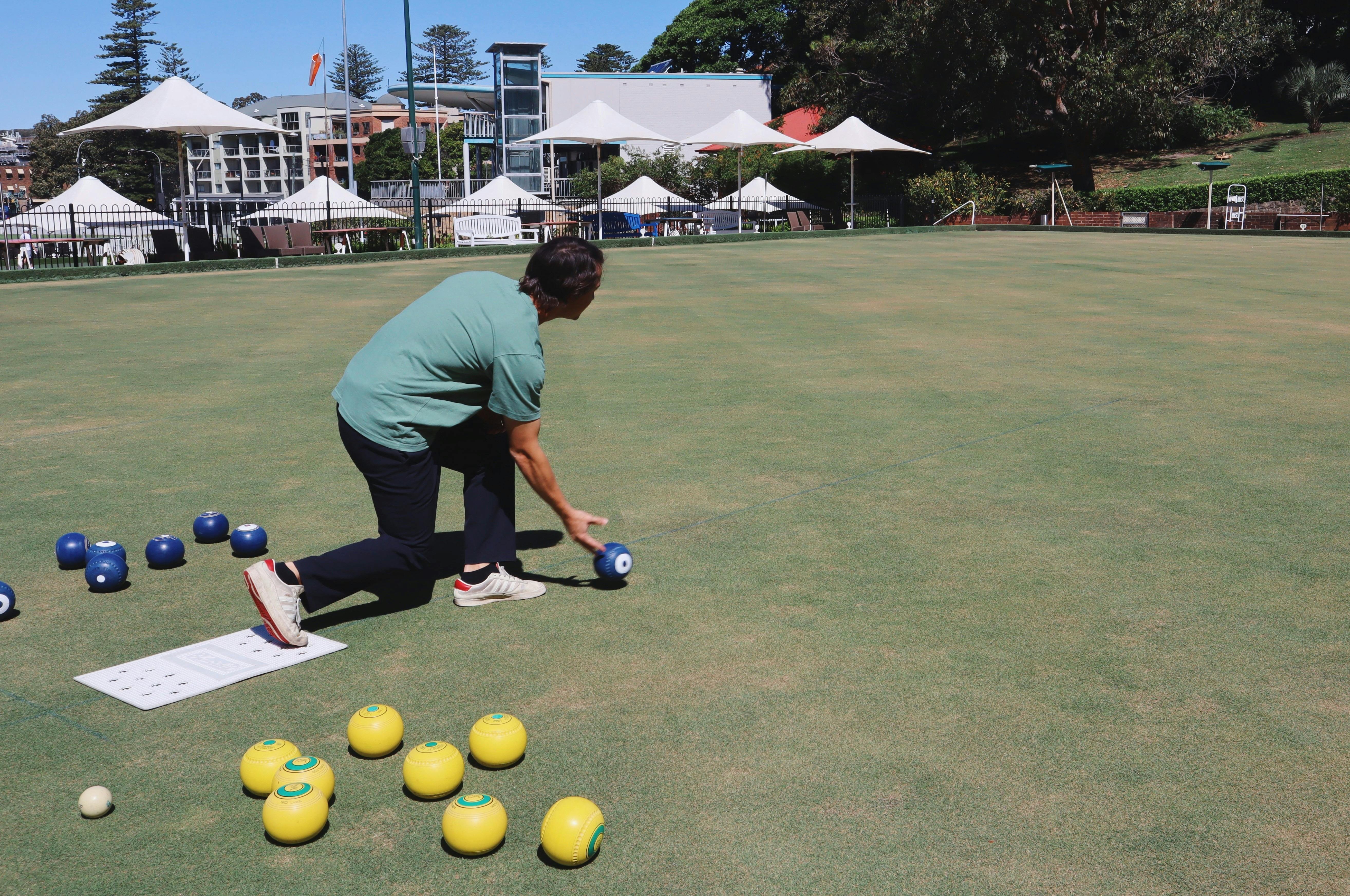 A man bowling a bowl on the green.