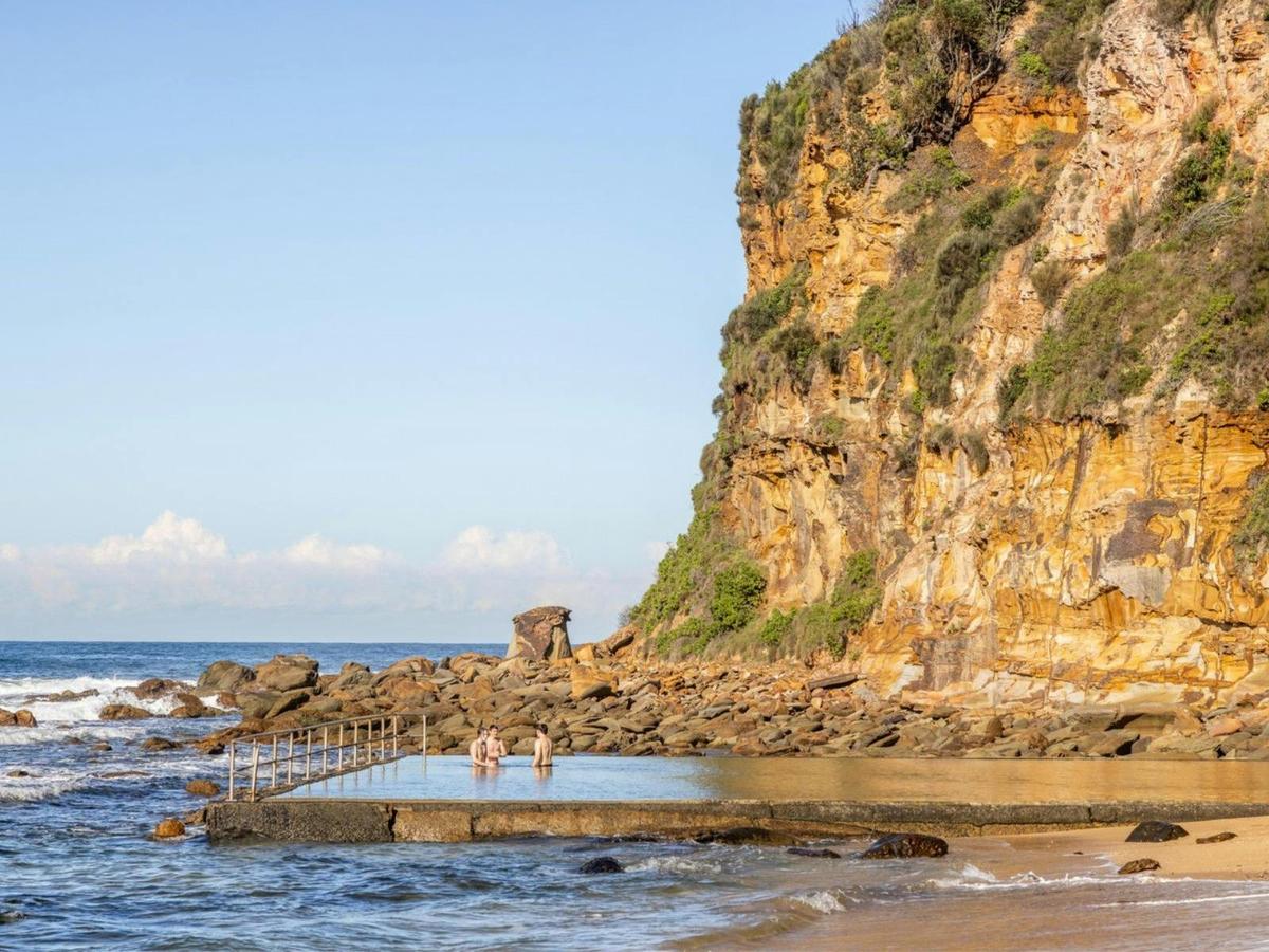 Ocean Pool nestled beneath a dramatic sandstone cliff at Macmasters Beach