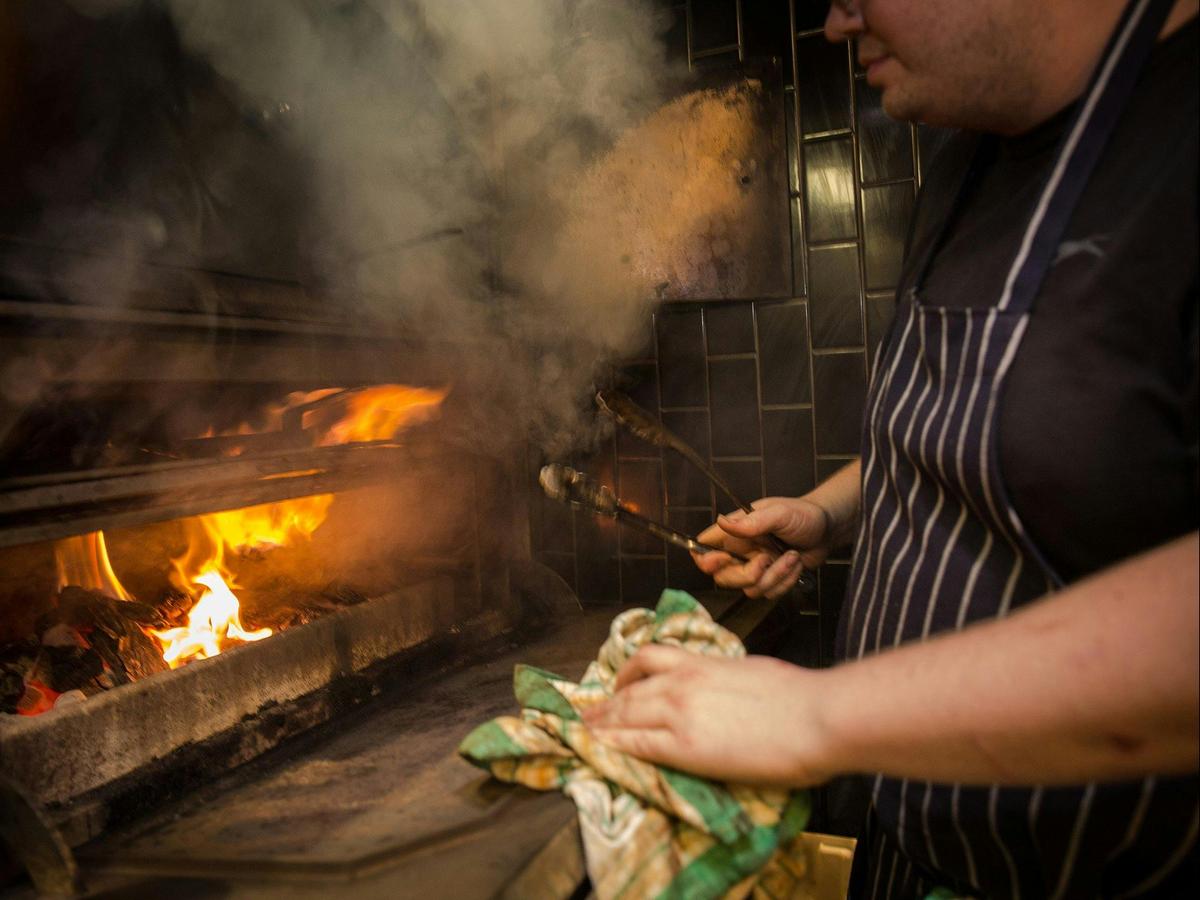 Chef in front of an open fire grill