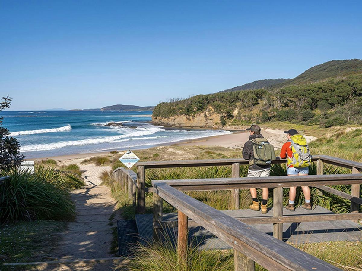 Visitors looking at the ocean views from a wooden platform, Pretty Beach picnic area. Credit: John