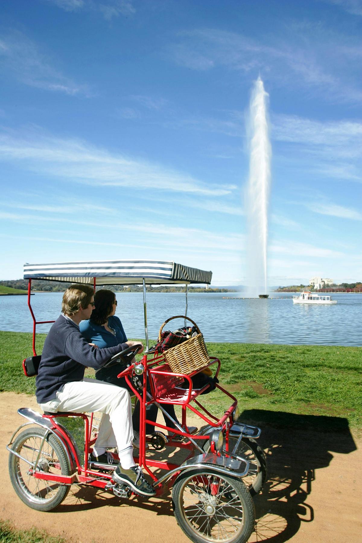 Couple cycling past Captain Cook Memorial Jet