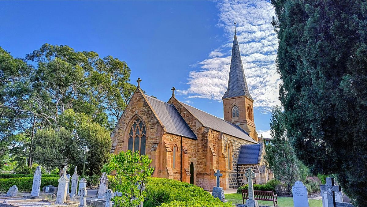 Ancient graveyard surrounding stone church with park and gardens