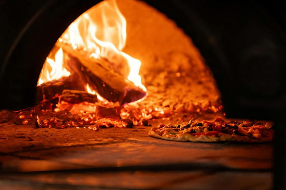 Pizza cooking in woodfired oven