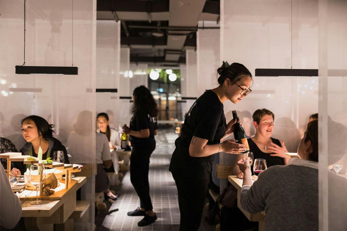 Service staff talking to patrons sitting at tables