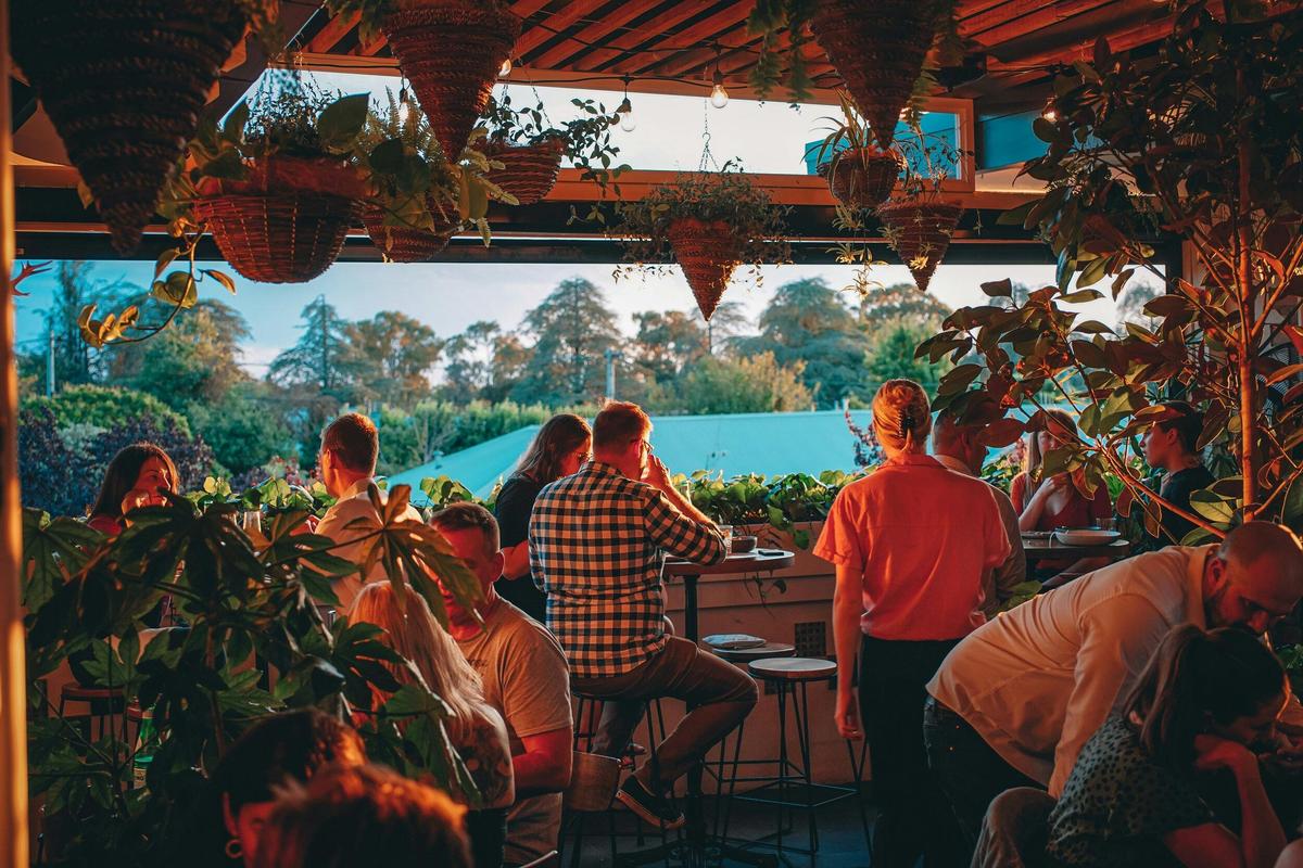 Group of people sitting watching sunset from upstairs bar