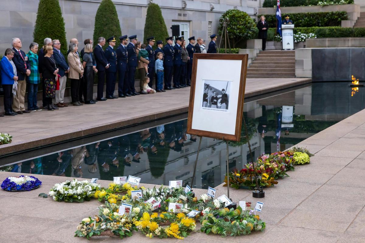 Wreaths at the base of the Pool of Reflection and photo of person commemorated.