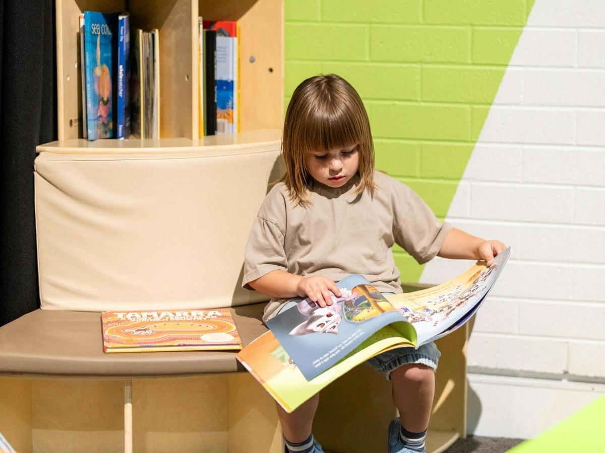 A child reading a book at Questacon