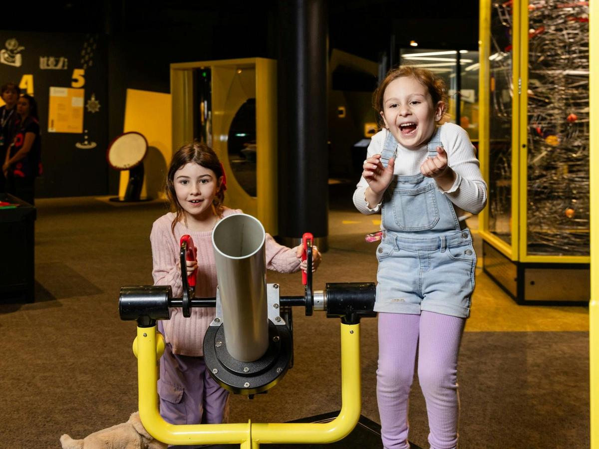 Two young girls playing with an exhibit at Questacon