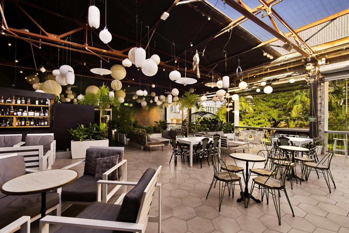 A terrace with balloons and seating overlooking a tree park in Darwin City