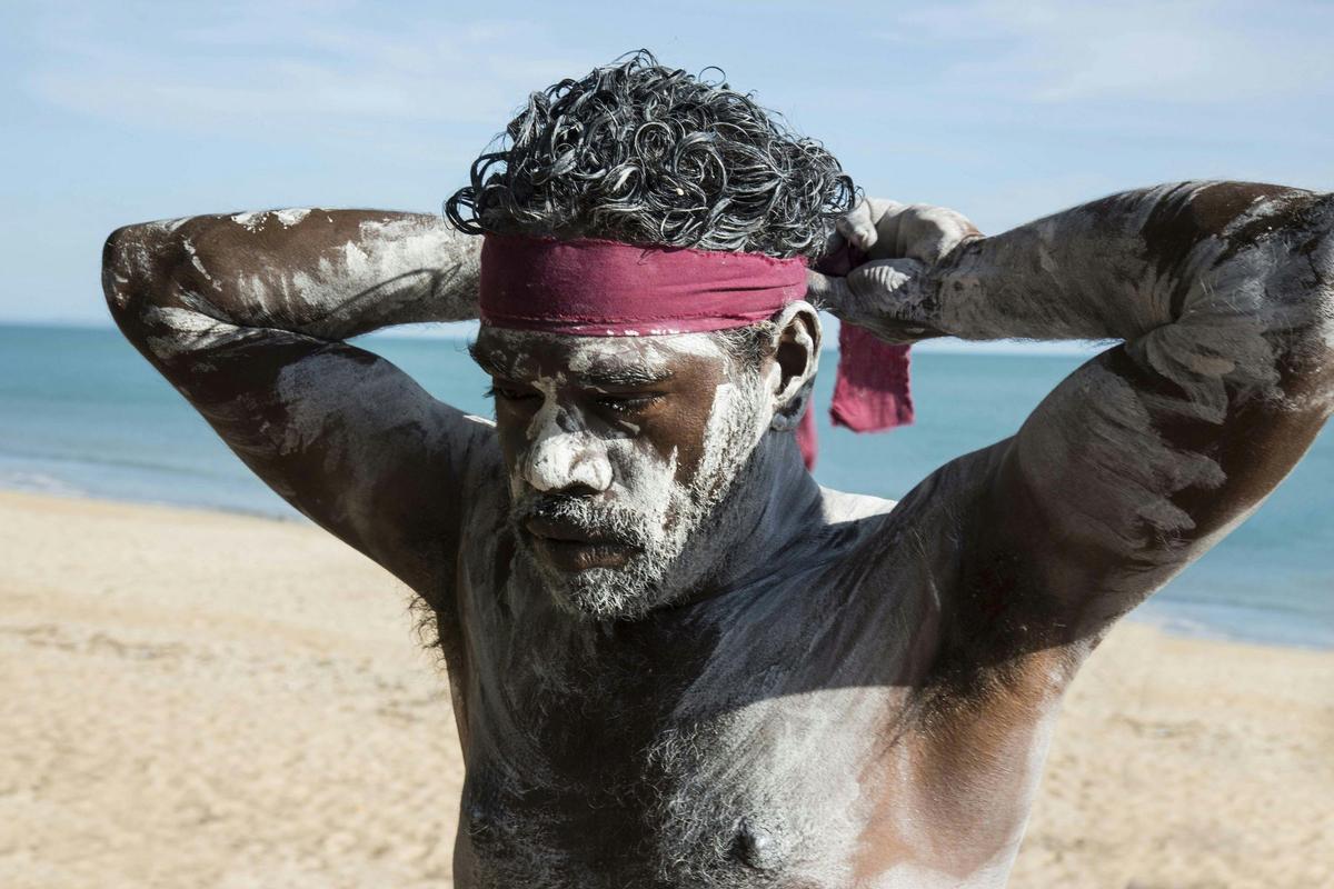 Aboriginal man tying on a bandana in East Arnhem Land