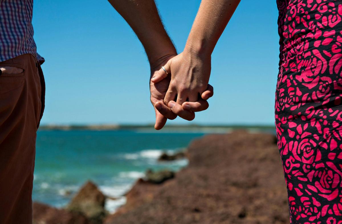 Couple at beach holding hands
