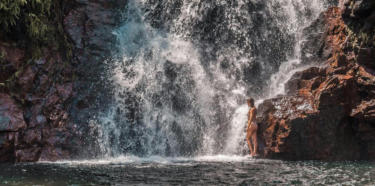 Girl at the bottom of a waterfall in Litchfield National Park