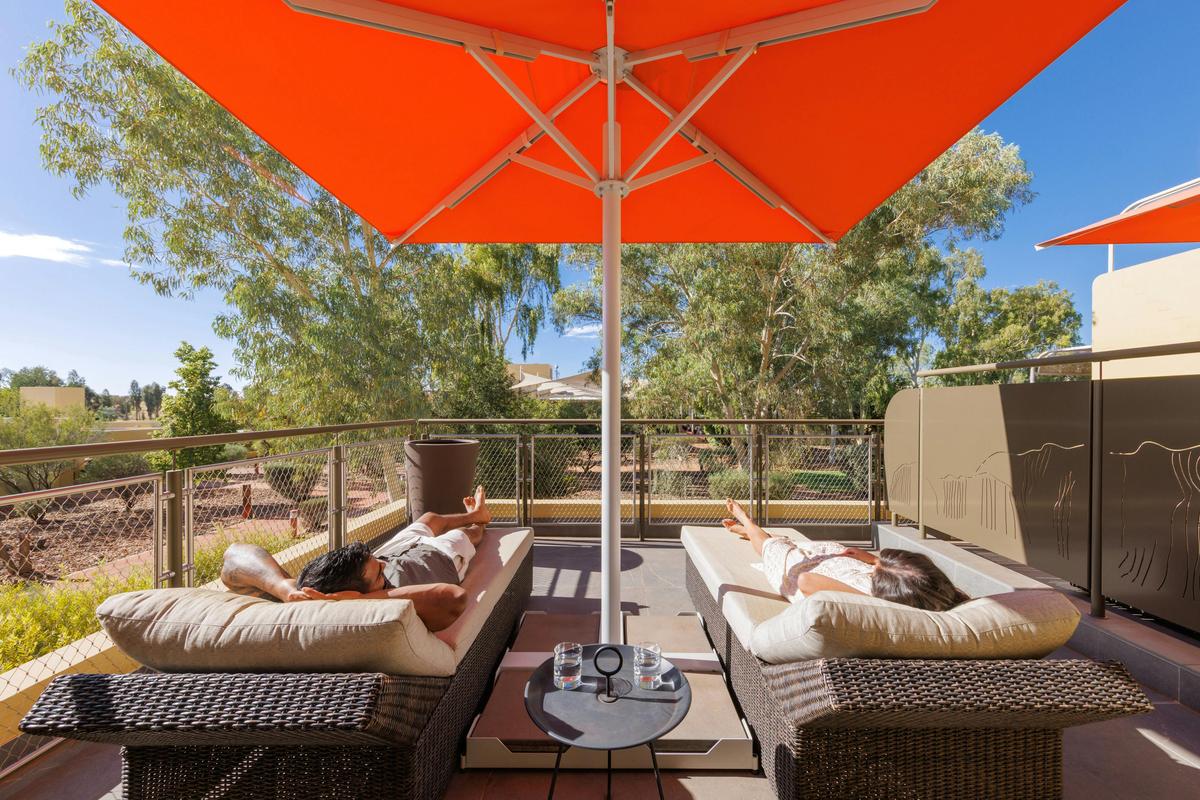 Guests relaxing on lounges in a Terrace Room at Sails in the Desert