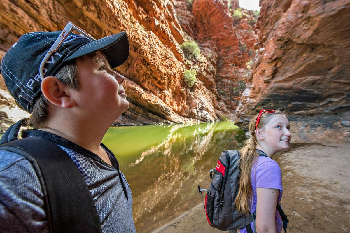 Two children with backpacks exploring Simpsons Gap