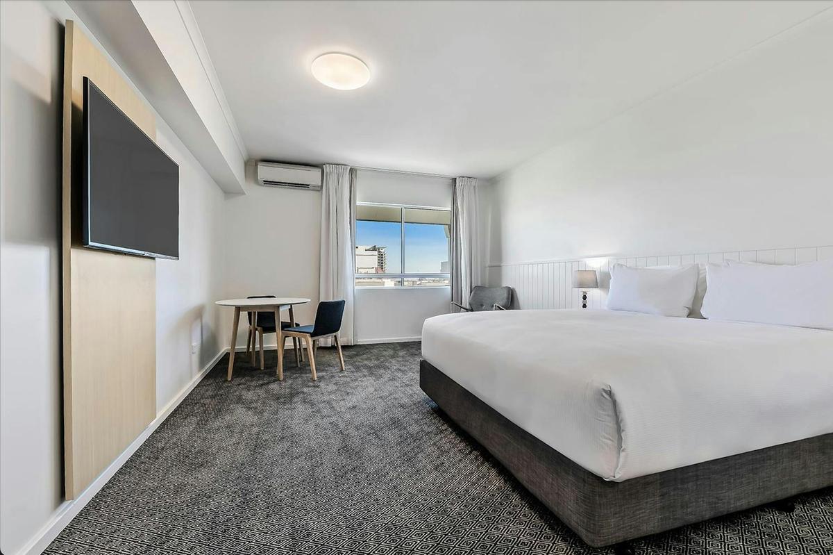Executive King room featuring a king bed, seating area and smart TV.