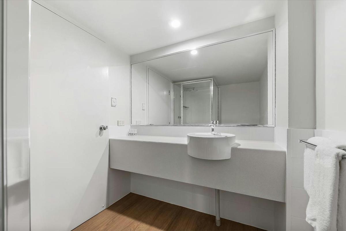 Modern ensuite bathroom with large mirror and walk in shower.