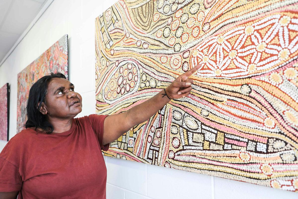 Artist Esther Bruno Nangala explaining her Bush Raisin Dreaming painting.