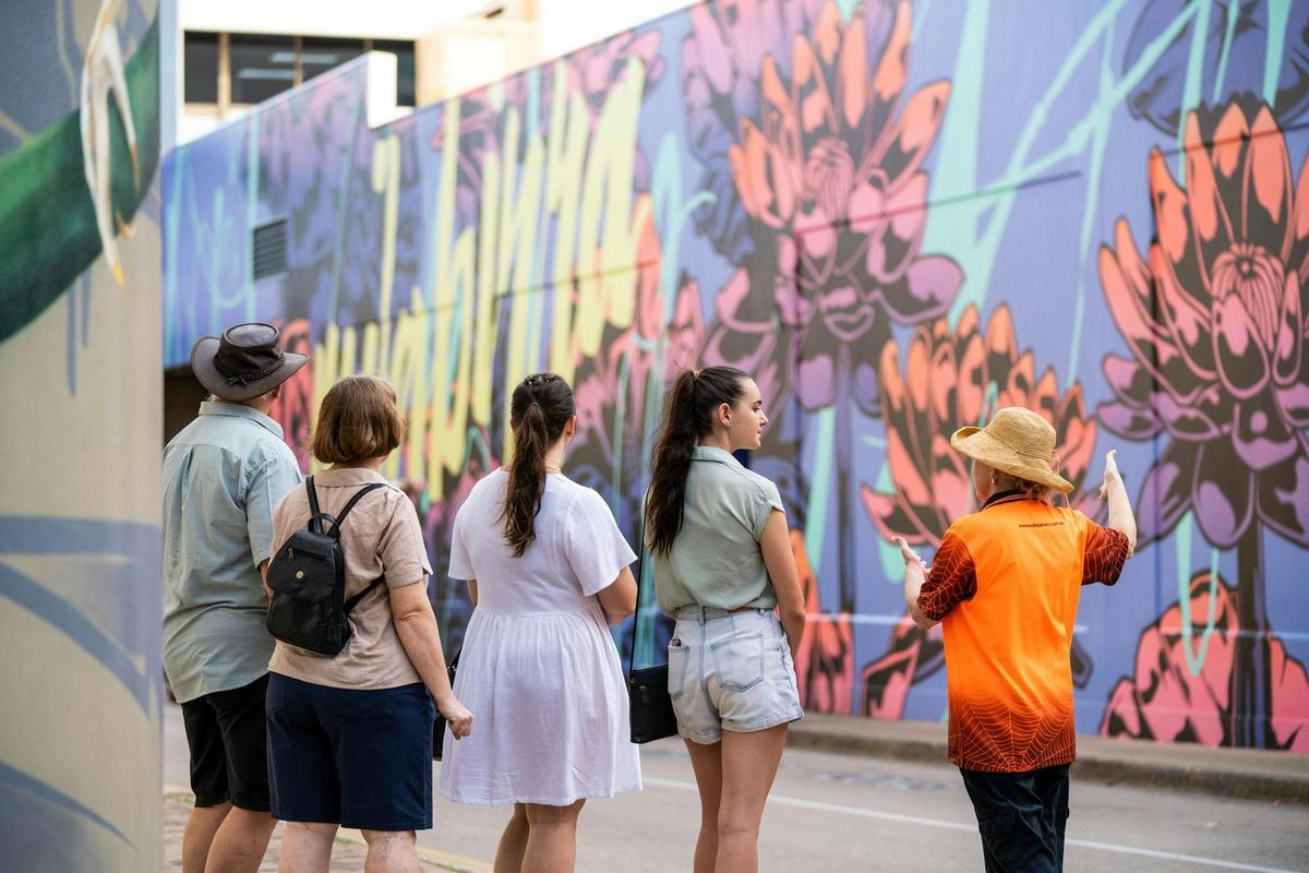 Walk Darwin guide shows guests a street art mural by George Rose