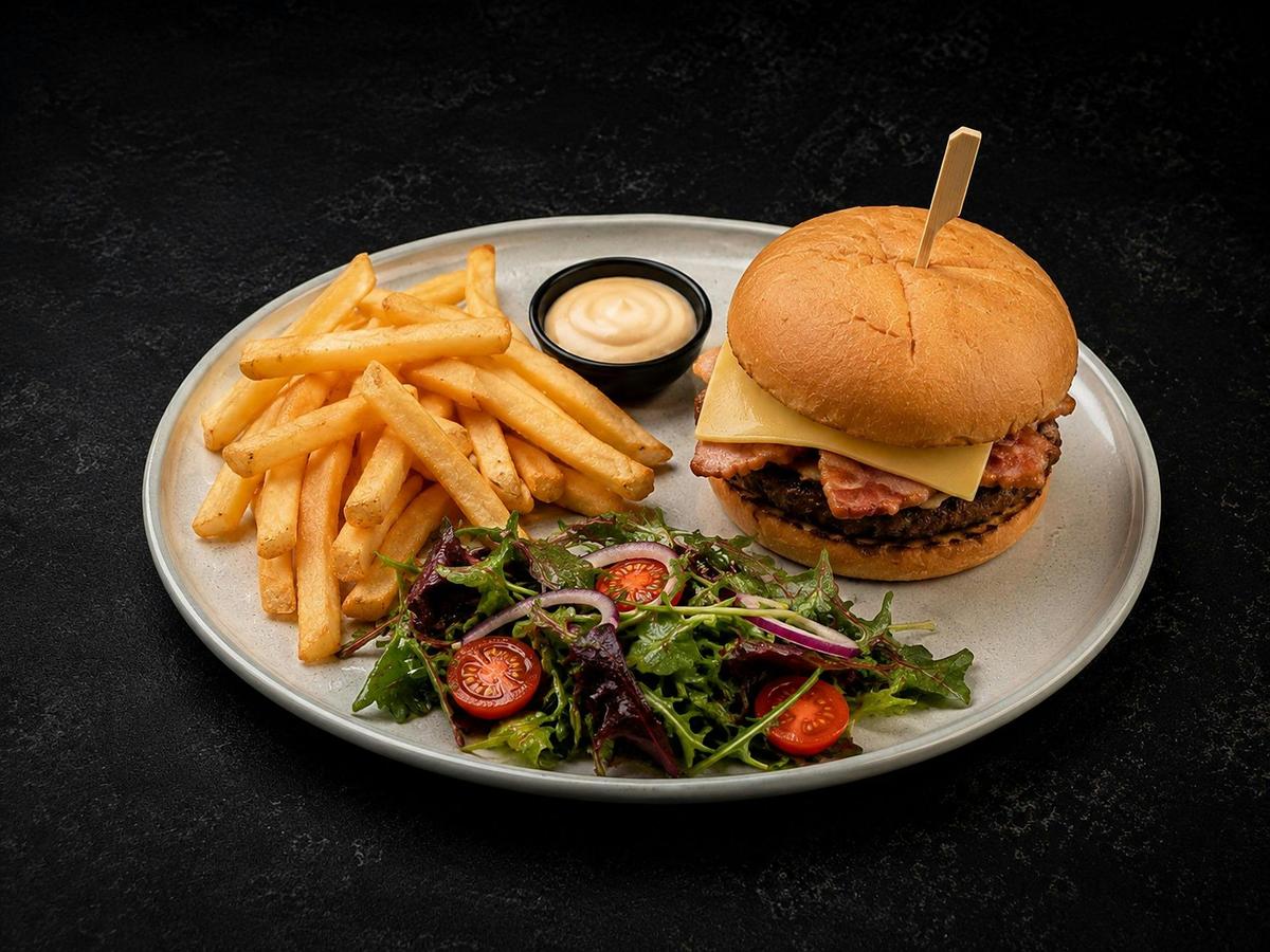 Beef and bacon burger with chips and salad