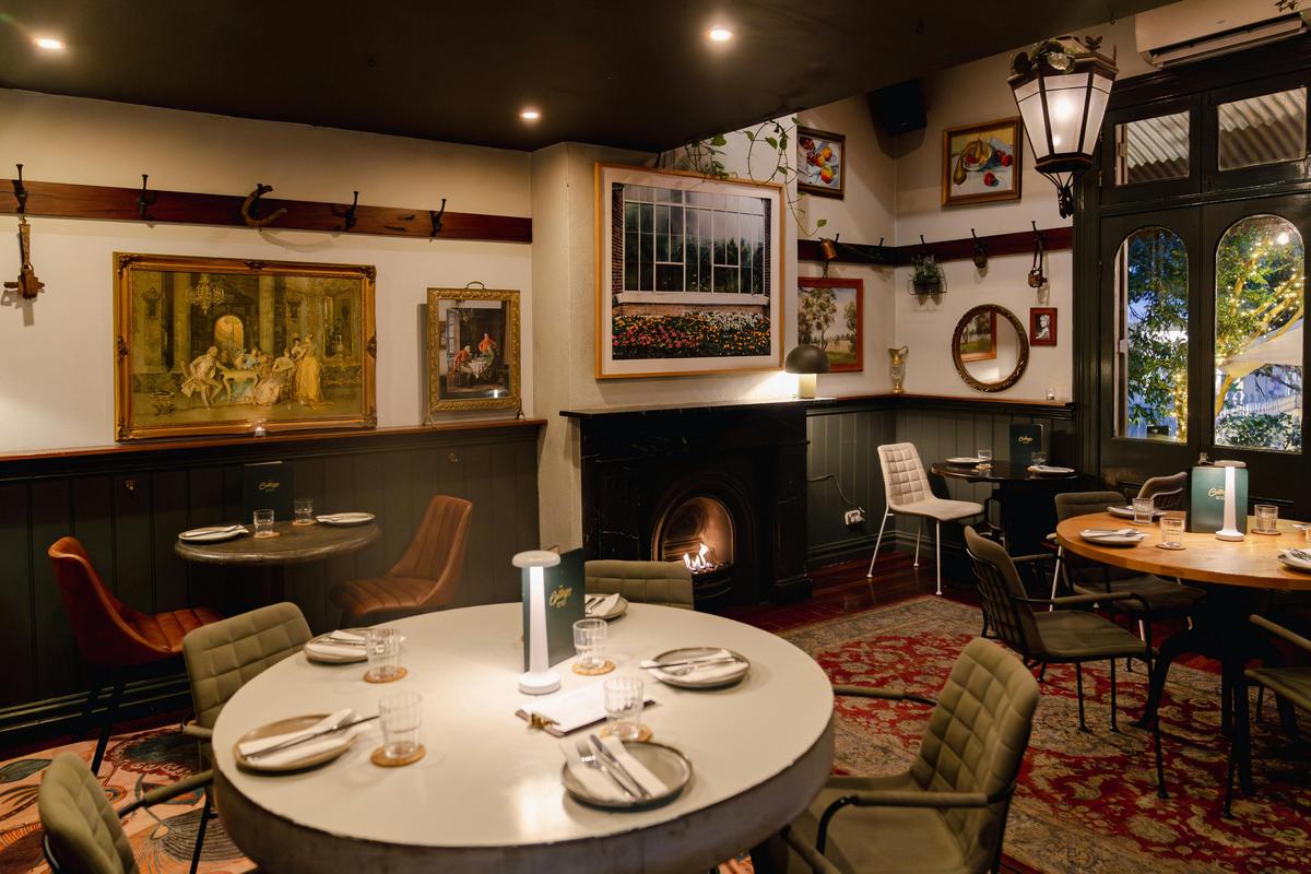 With its roaring fireplace, gallery wall of vintage artwork, and warm, moody lighting.