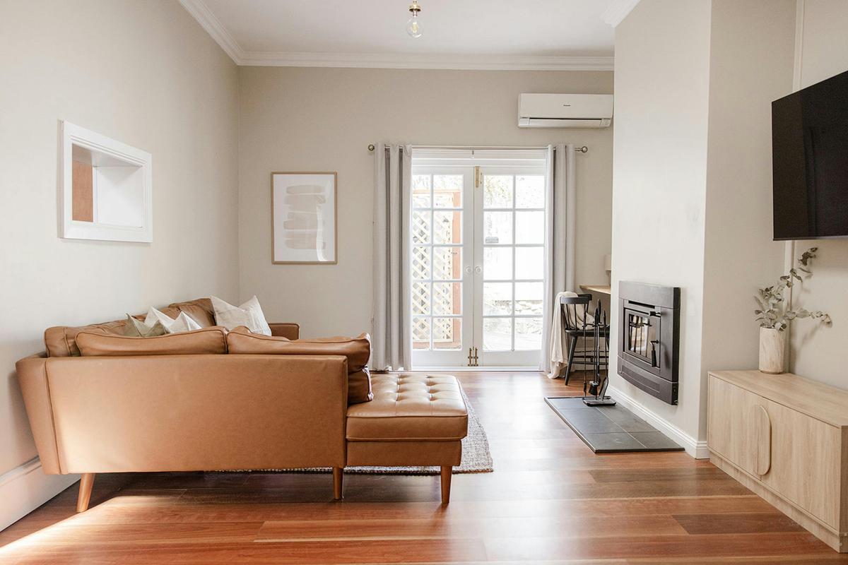 Spacious lounge room with a wood fire place over looking our private courtyard