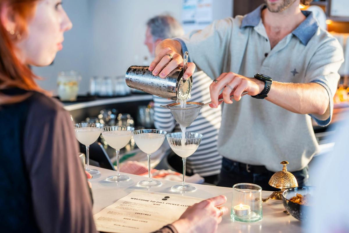 Bartender pouring cocktails at Dill Pickle Club