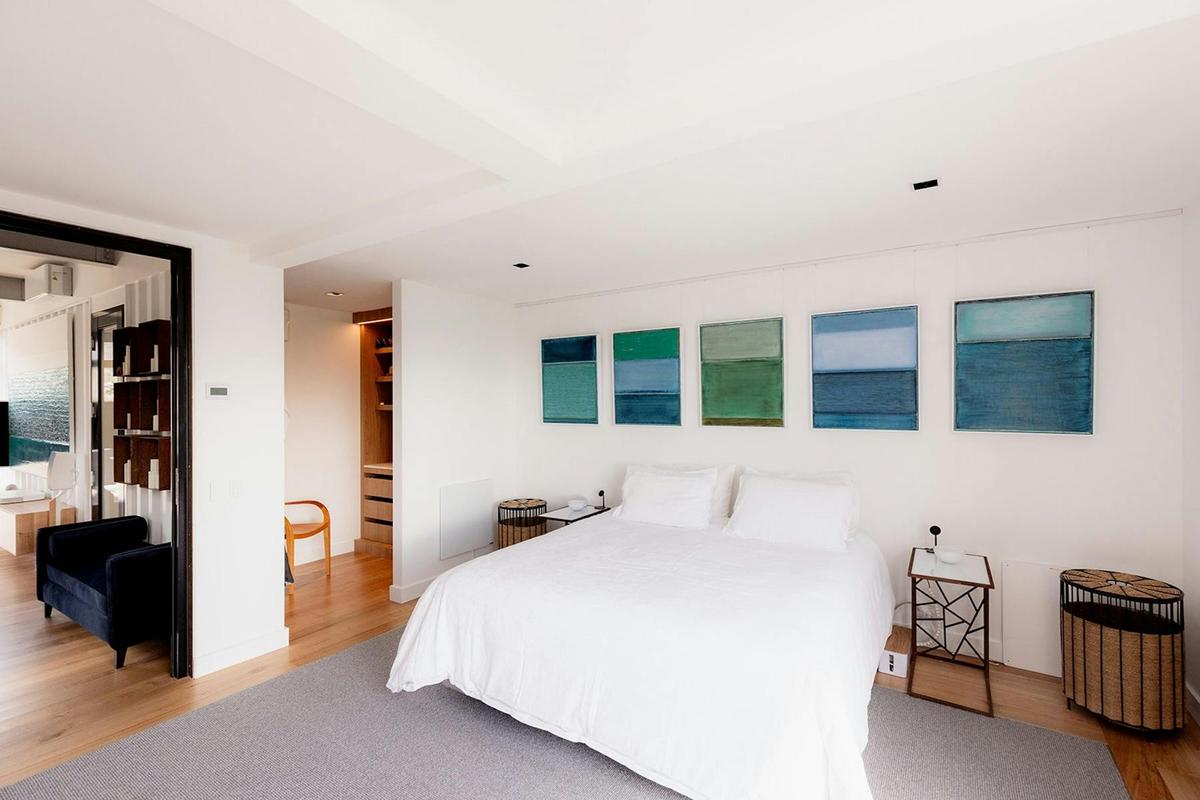 Serene master bedroom with king bed, large window, his/ her waredrobe, and art feature wall.